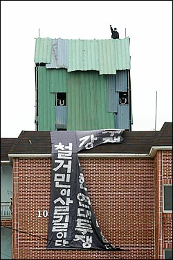 철거민들이 건물 옥상에 설치한 망루에서 구호를 외치고 있다.
 